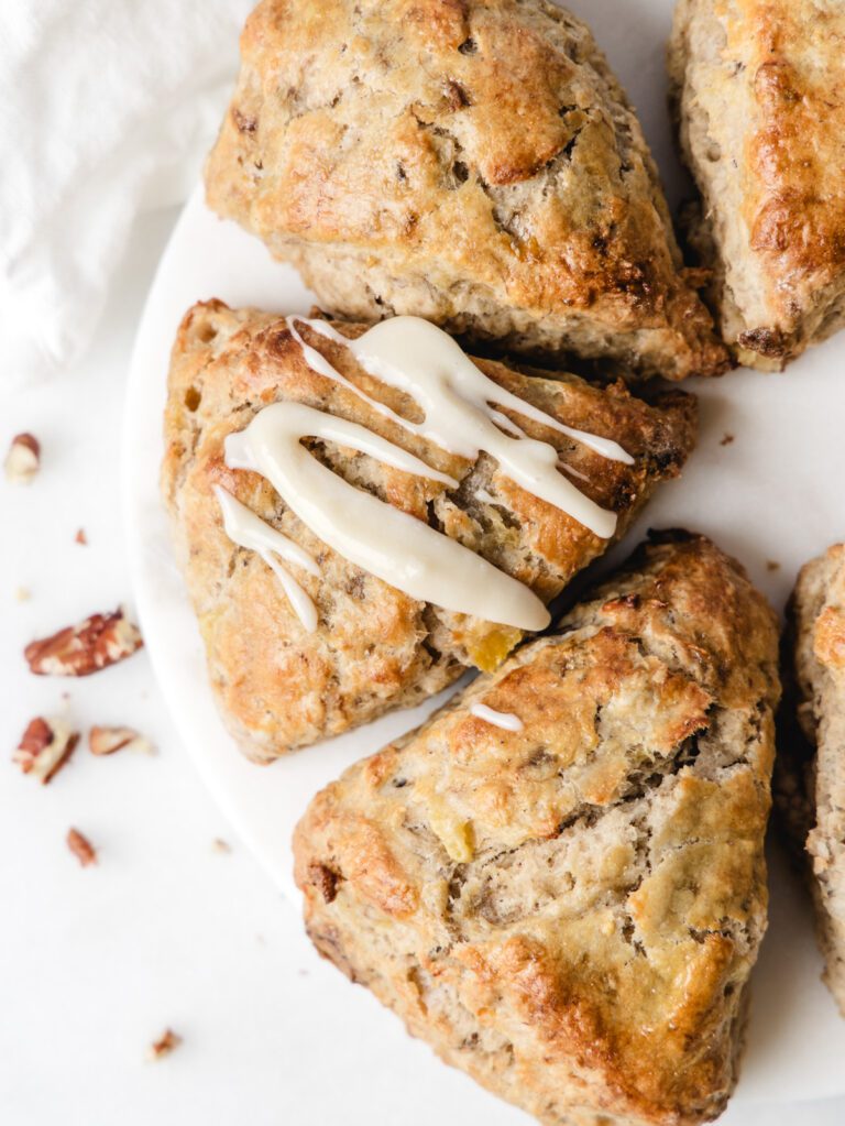 Scones on a circle marble board with glaze on one.