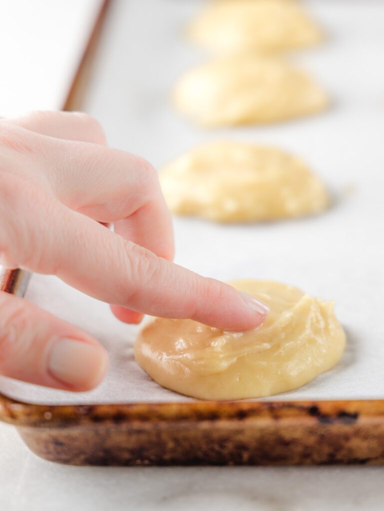 Smoothing choux pastry with finger.