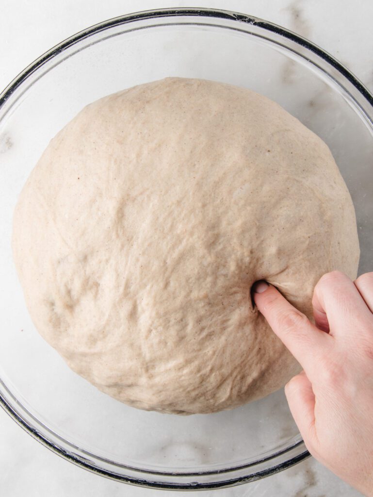 Poking risen bread in bowl