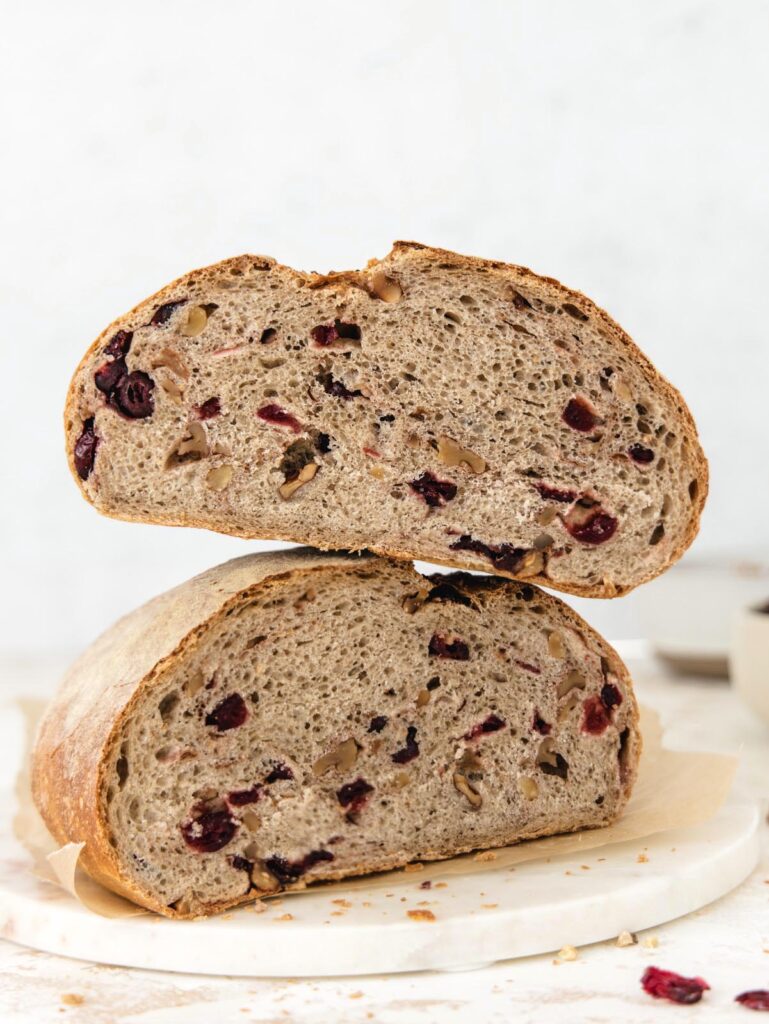 Bread sliced in half and stacked with cranberries inside.