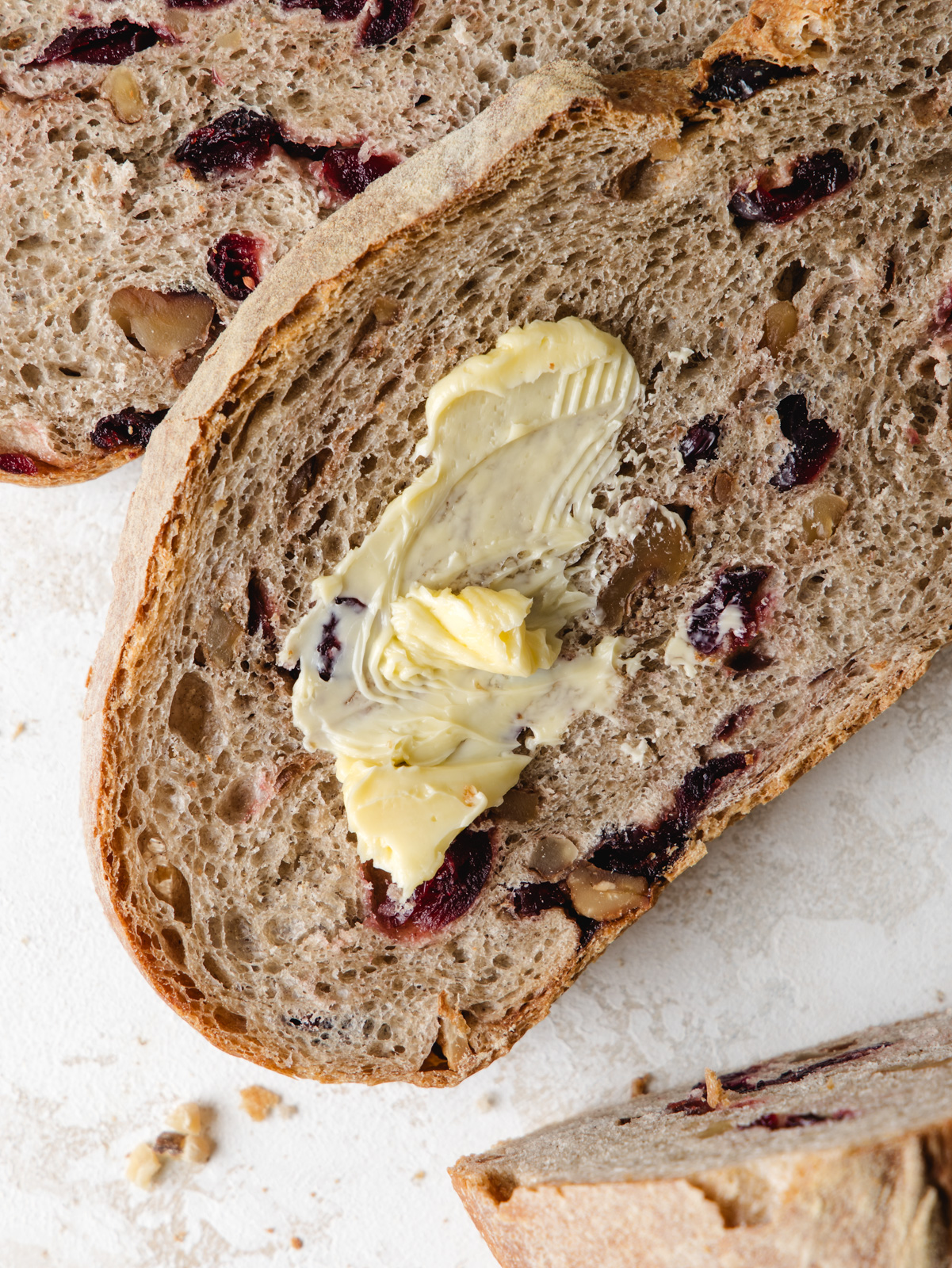 Sliced cranberry bread with butter smear.