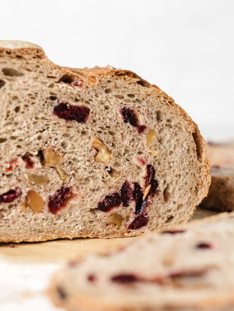 Straight view of sliced bread with cranberries and walnuts.