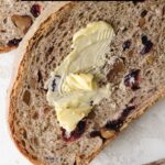 Sliced cranberry bread with butter smear.