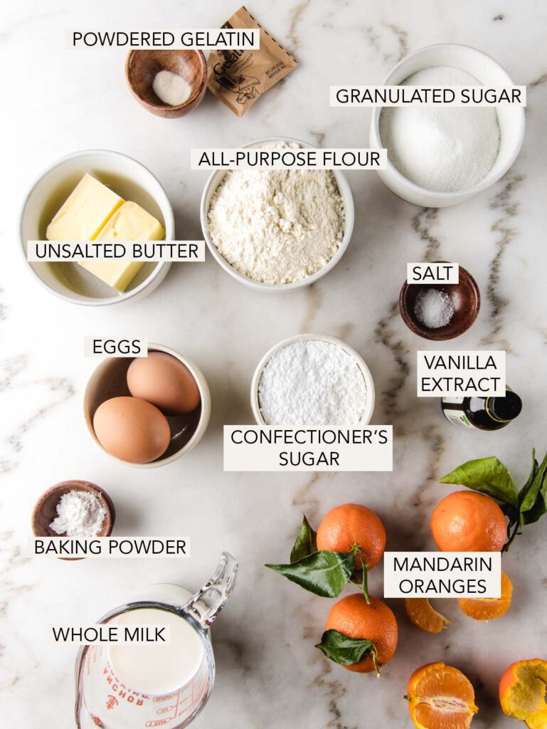 Ingredients for mandarin orange cake in bowls with labels.