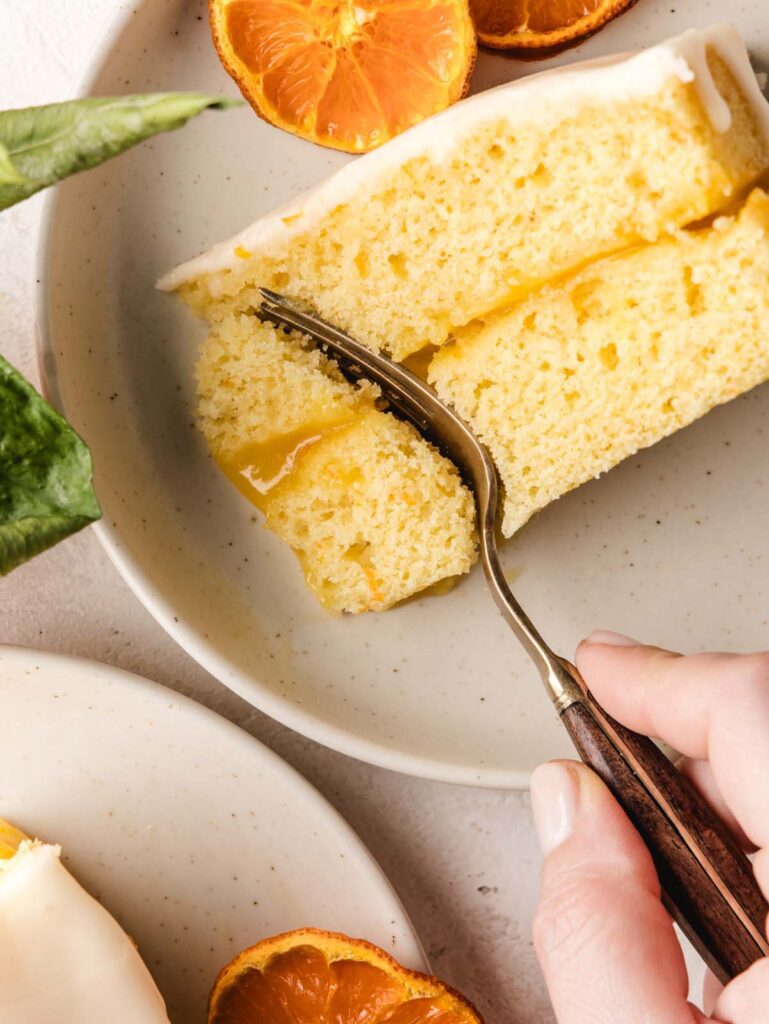 Person taking forkful of orange cake.