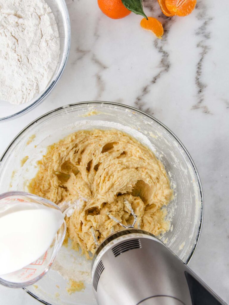 Pouring milk into cake batter.
