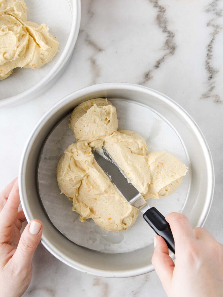 Smoothing cake batter into cake tin.