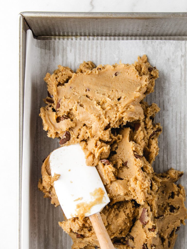 Smoothing blondie dough in baking pan.
