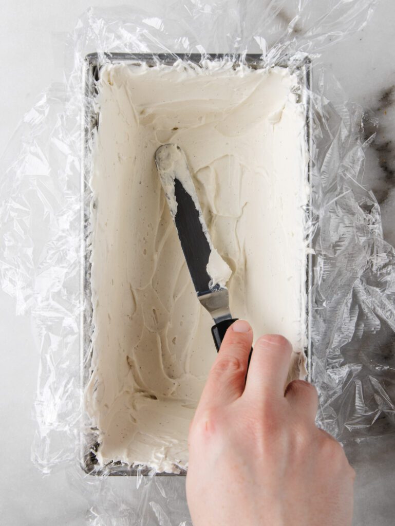 Spreading cream in cake tin.
