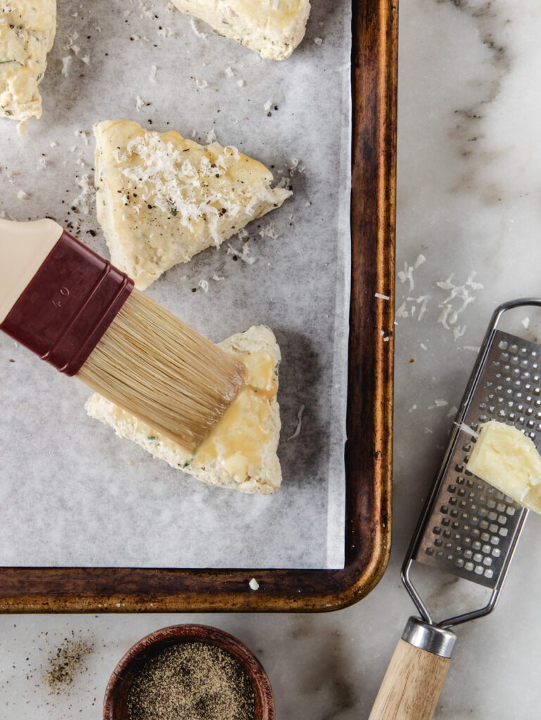 Brushing scones with egg wash.