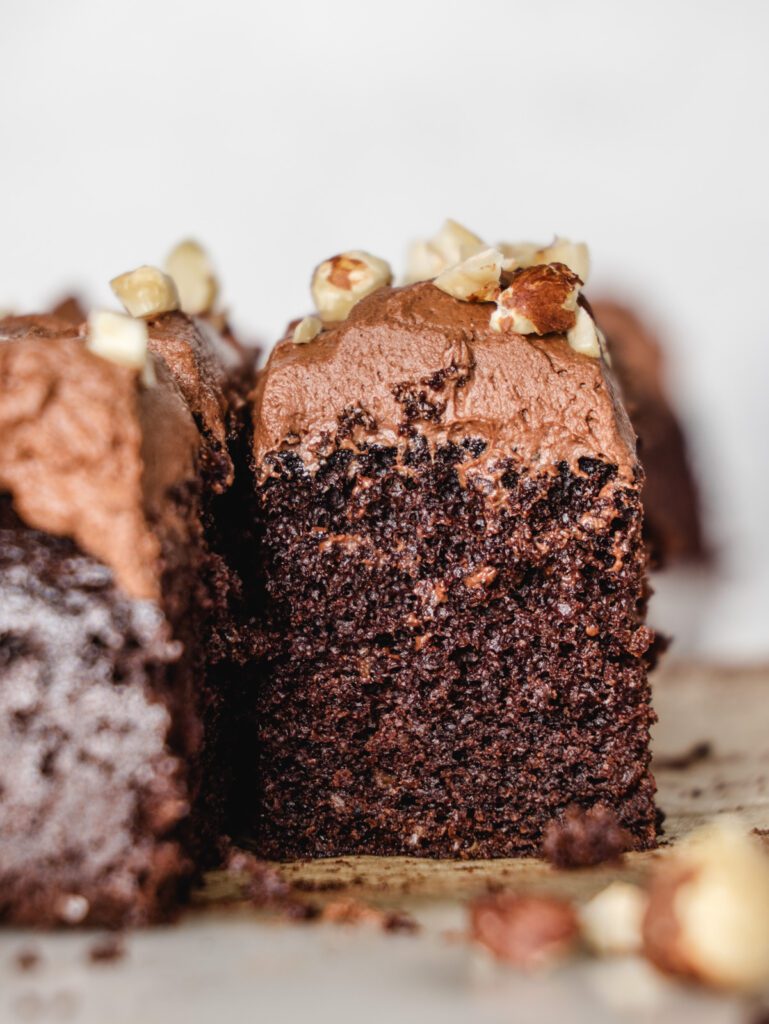 Side view of chocolate cake sliced on parchment paper.
