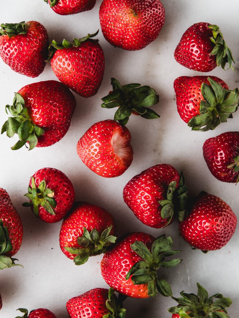 Strawberries scattered on marble.