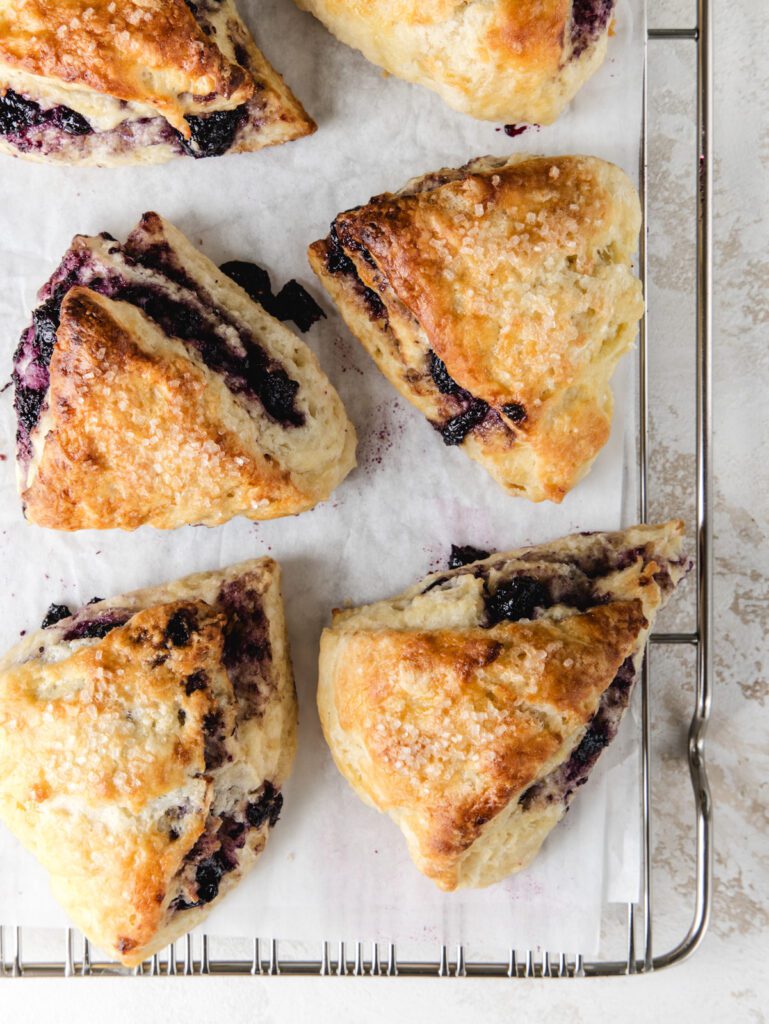 Scones with jam inside on cooling rack.