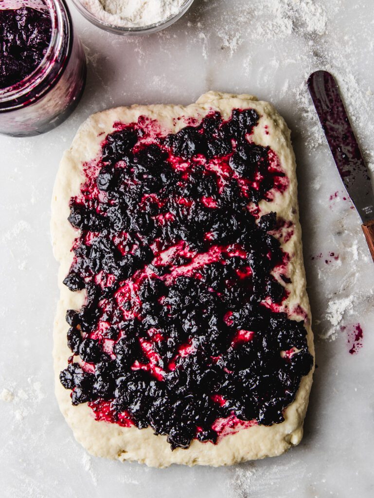 Jam spread on rectangle of scone dough.