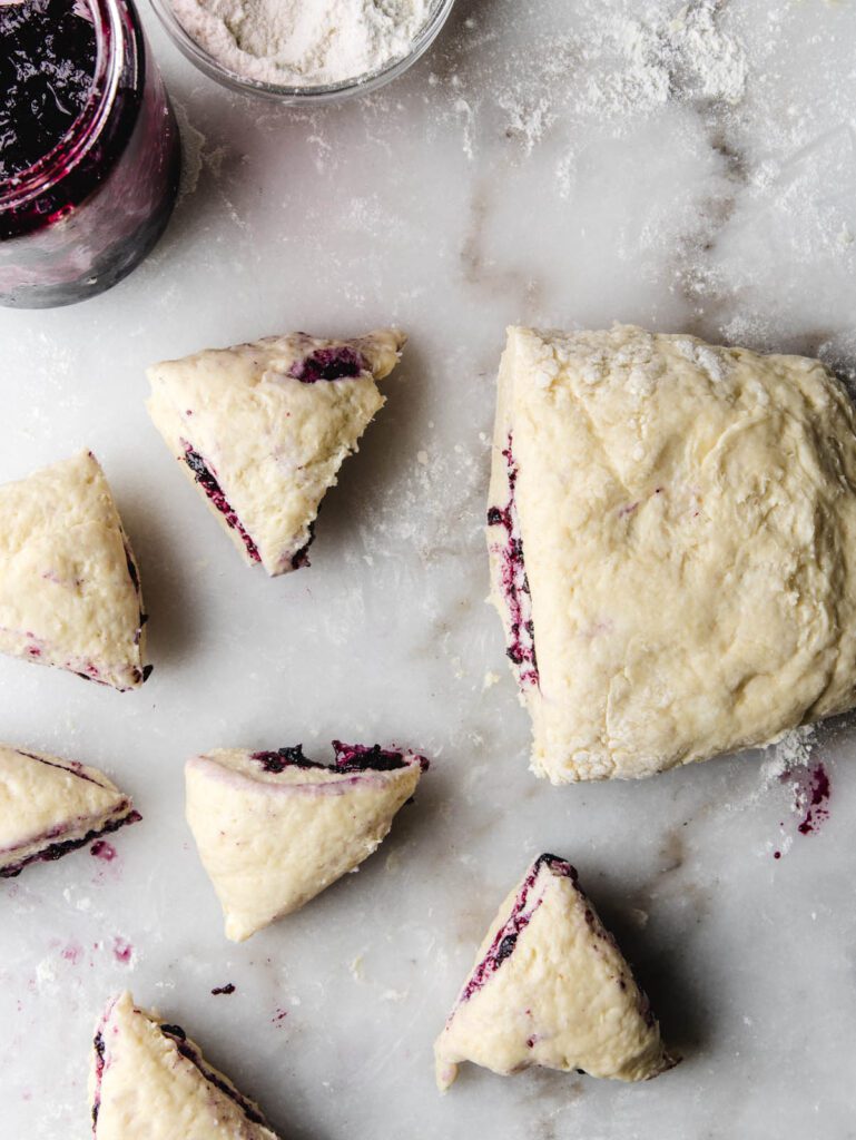 Sliced scone dough on marble.