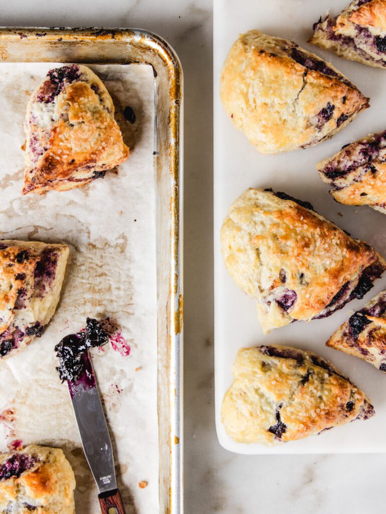 Scones scattered on baking tray and serving borad.