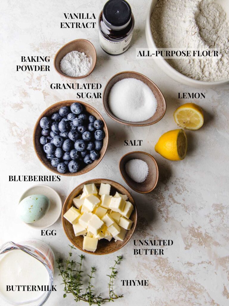 Ingredients for blueberry jam scones in bowls with labels.